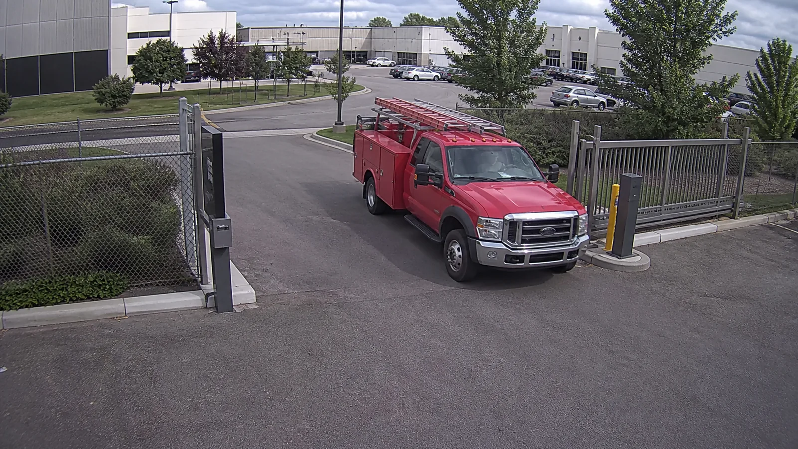 Simulated vehicle-gate security-camera view showing a red utility truck